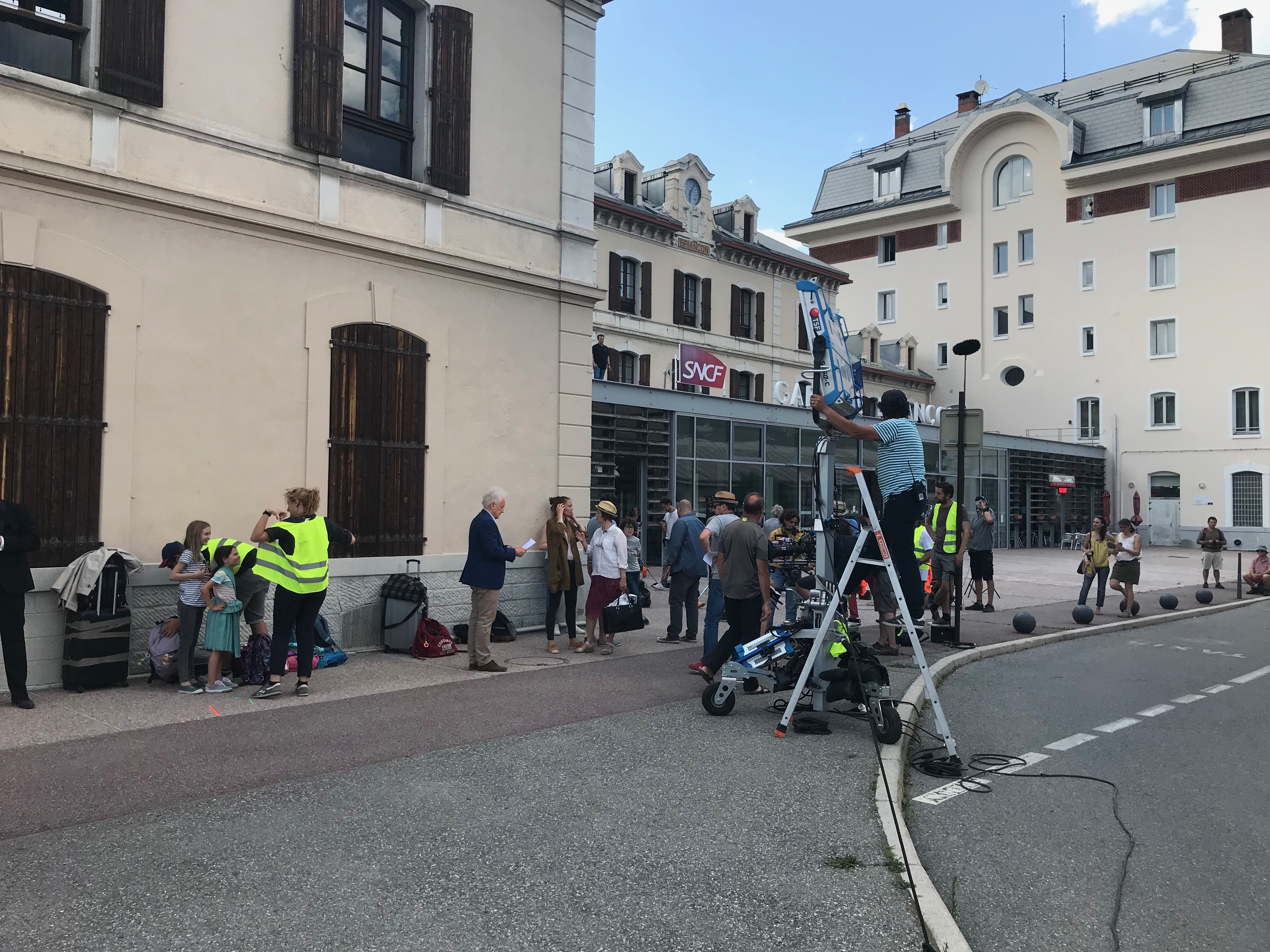 Arrivée à Briançon en plein tournage du film ''La Grande Déraille'' d’André Dussollier, pantalon beige et veston bleu.