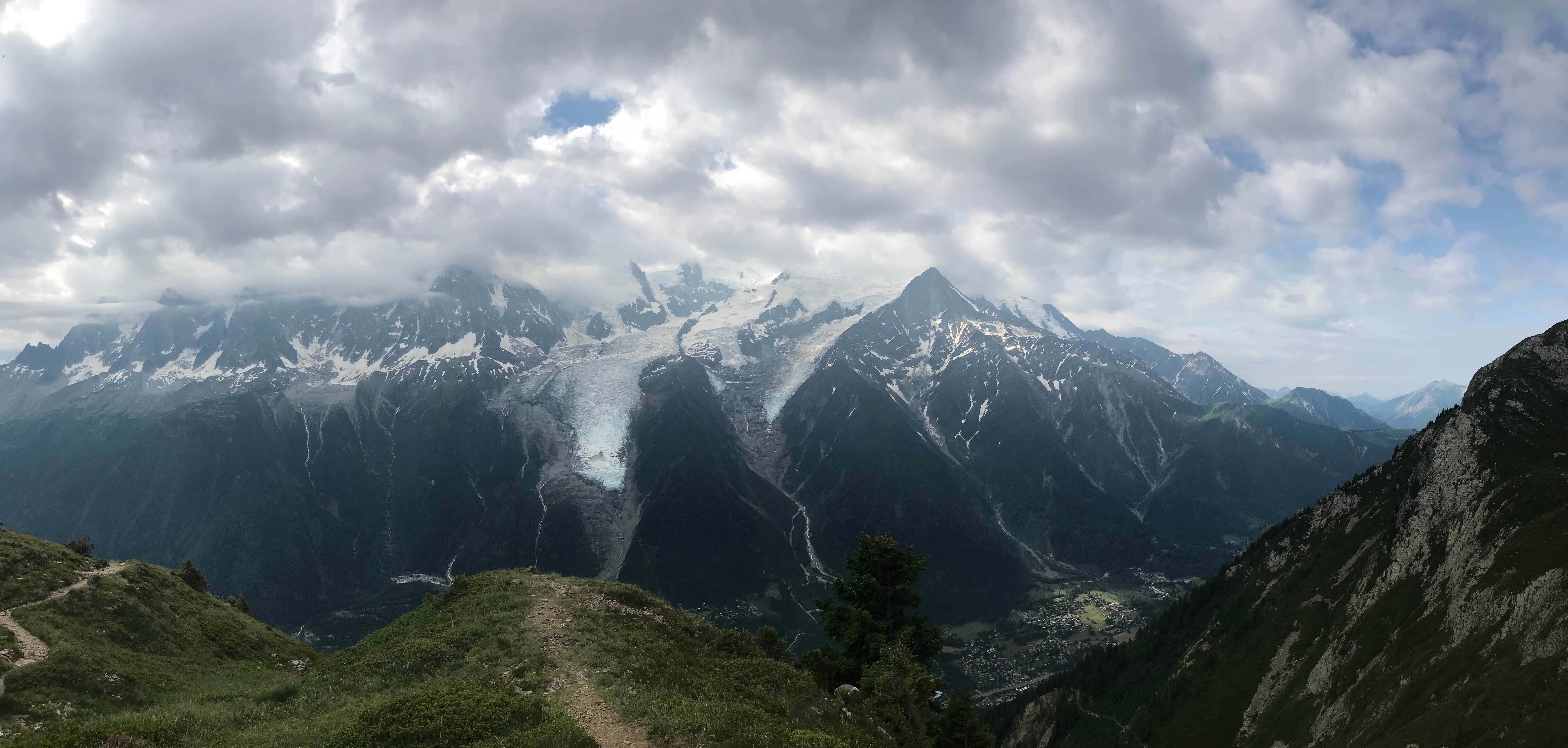À deux pas du refuge de Bellachat, la vue sur les Houches dans la vallée et le massif du Mont Blanc dans les nuages. Marche et Rêve / Jacky Fabis